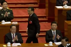 在人大会议开幕式上，中共总理李克强在中国主席习近平身边走过，上台做工作报告(2016年3月5日)