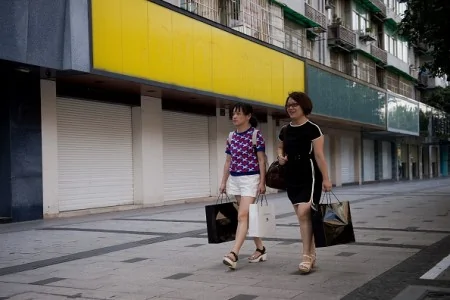9月2日，兩名女子經過幾乎全部關閉的街道商店門前。（NICOLAS ASFOURI/AFP/Getty Images)