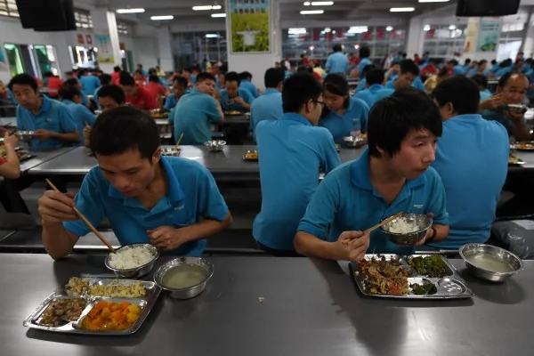 中國有很多35歲以上的男性移工，被迫下崗後很難再找到工作。圖為在東莞某鞋廠餐廳吃午餐的員工。(GREG BAKER/AFP/Getty Images)
