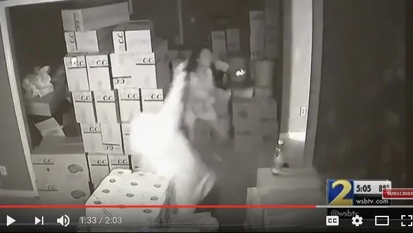監控錄影顯示，這么女子邊開槍邊沖向劫匪。（視頻截圖）