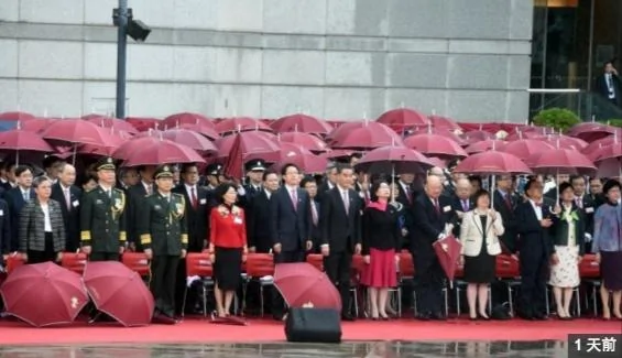 10月1日，香港特首梁振英（左6）和中国中央人民政府驻香港特别行政区联络办公室主任张晓明（左5）在雨中出席升旗仪式（中新社）