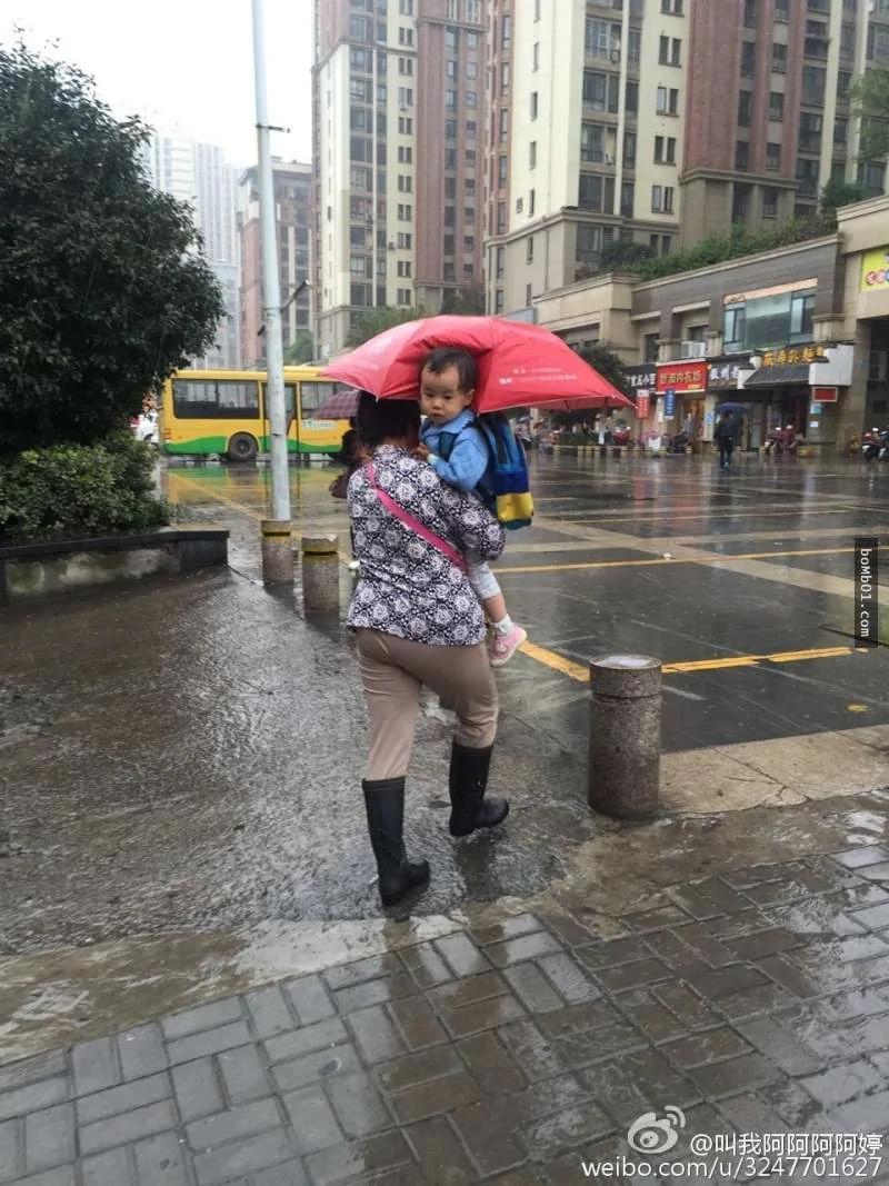 奶奶在下雨天为孙子打伞的照片一上传立马疯传……