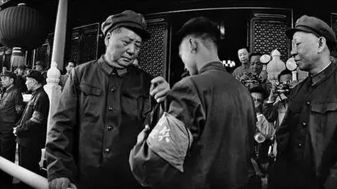 1966年8月18日，毛澤東首次在天安門接見紅衛兵，由此掀開了紅衛兵運動，「文革」初期，毛澤東8次接見紅衛兵，接見人數超過了1200萬。圖為紅衛兵正為毛澤東帶袖章。