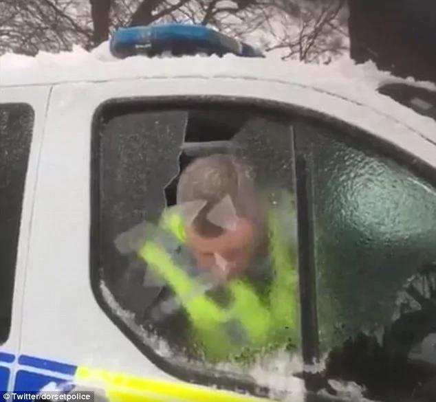滑稽!英一警察用头撞去车窗冰块 走红网络!