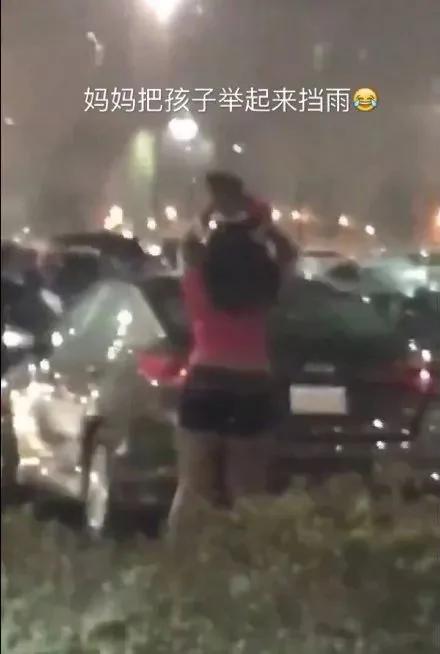 美国一母亲把孩子举起来挡雨 网友:同一个世界 同一个亲妈