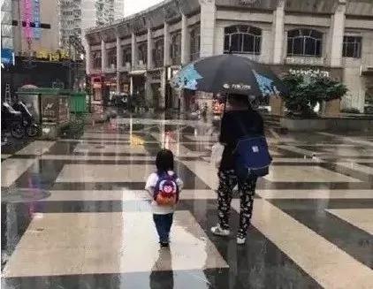 美国一母亲把孩子举起来挡雨 网友:同一个世界 同一个亲妈