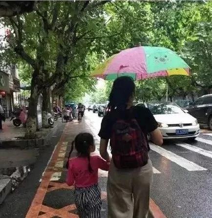 美国一母亲把孩子举起来挡雨 网友:同一个世界 同一个亲妈