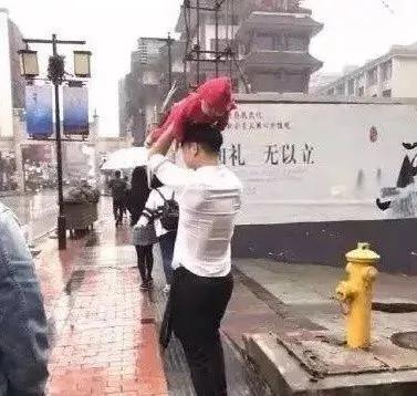 美国一母亲把孩子举起来挡雨 网友:同一个世界 同一个亲妈