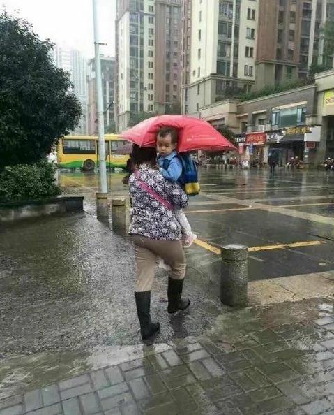美国一母亲把孩子举起来挡雨 网友:同一个世界 同一个亲妈