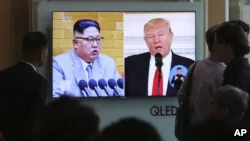2018年4月21日，人們在韓國首爾火車站觀看電視新聞，屏幕上顯示美國總統川普和朝鮮領導人金正恩。