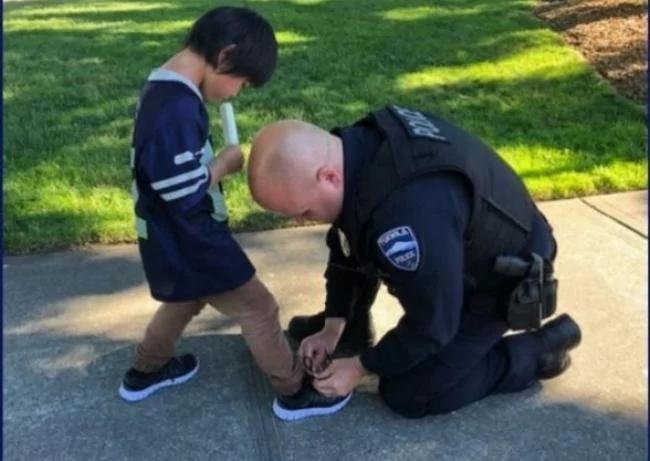 华盛顿州塔克维拉警局脸书专页日前发表了警察为一名黑发男童穿鞋的照片,网友大赞。(取自脸书)