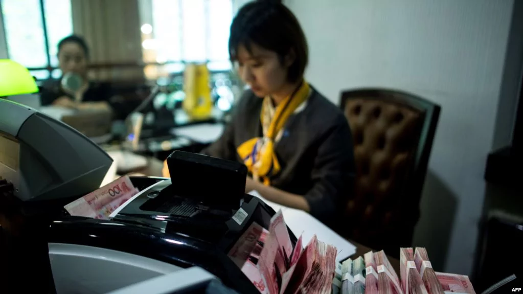 2018年8月8日在上海的一家銀行，員工使用點鈔機點算100元（相當於14.6美元）的鈔票。