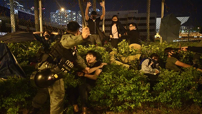 2019年11月19日，警察毆打並準備拘捕試圖離開香港理工大學的學生。（法新社）