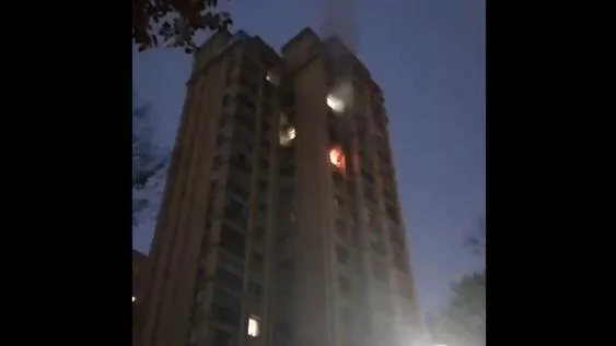 視頻可見，一幢高層建築有樓層着火，有人哭喊，疑似有人從高處墜下。（視頻截圖）
