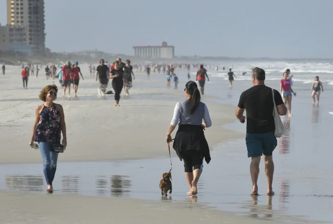 佛州有限度放松居家避疫限制，民众迫不及待地走上海滩。(美联社)