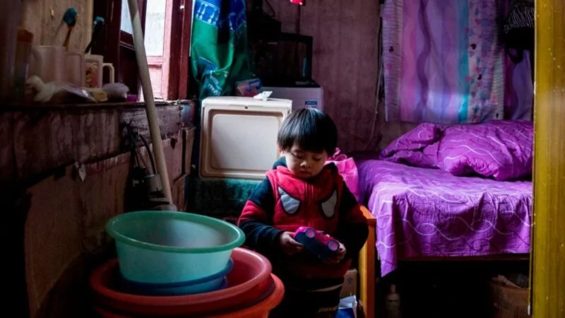 图为2017年12月26日，中国上海市老西门贫困农民工的一个孩子在拥挤杂乱的家中玩玩具。