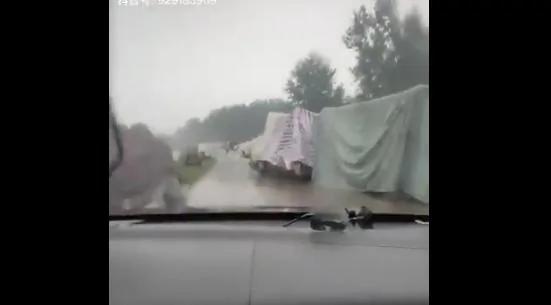 安徽某河堤排满了灾民们自己用塑料布、编织材料搭建的简易帐篷（视频截图）