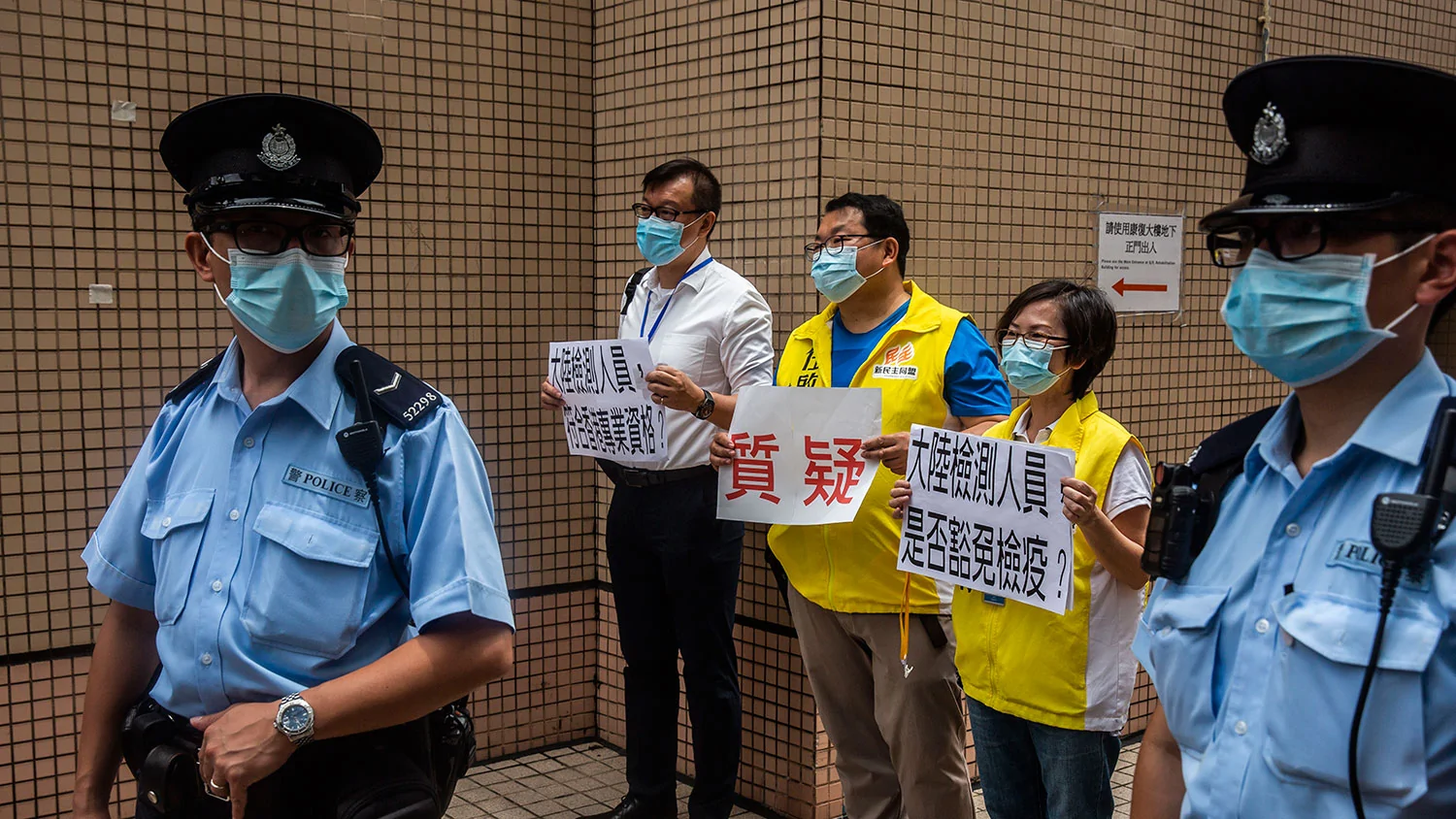 2020年8月2日，香港民主派议员刘志雄（左二），任启邦（中）和林淑菁（右二）在香港医管局外面抗议，反对中国协助在港进行武汉肺炎全民普筛。（AFP）