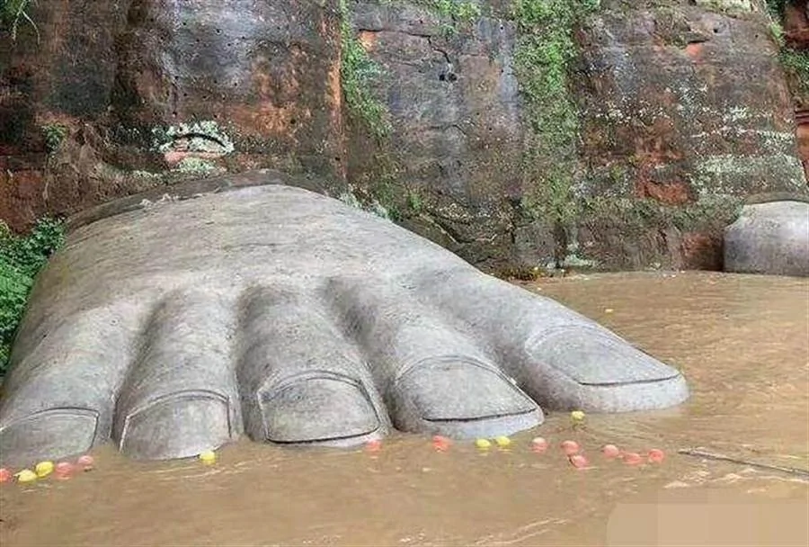 图为当地为乐山大佛的佛脚做了保护措施，以水泥完全包覆，避免被游客或洪水破坏。（图／网易）