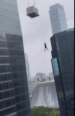 路人拍下惊悚视频：建筑工人被吊在数十米高空中