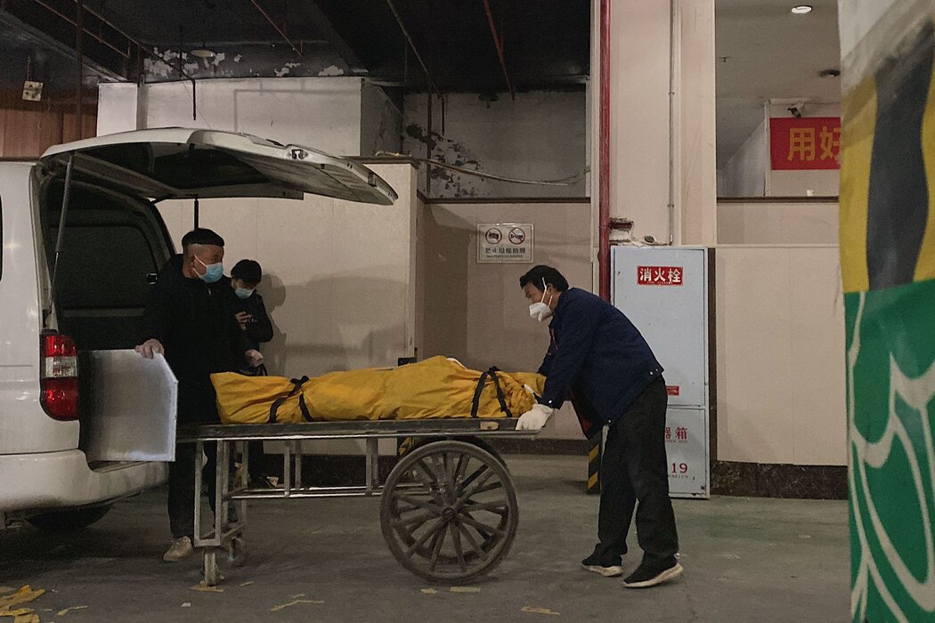 中国西南部城市重庆一个火葬场的工人正在卸载尸体，摄于12月。