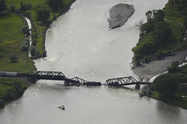 一列运载危险物品的货运列车24日在驶经蒙大拿州横跨黄石河的铁路桥梁时，桥梁突然坍...