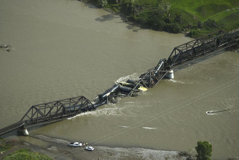一列运载危险物品的货运列车24日在驶经蒙大拿州横跨黄石河的铁路桥梁时，桥梁突然坍...