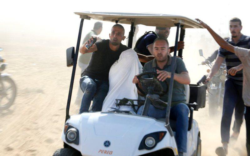 一名以色列俘虜（中）被哈瑪斯武裝人員帶上車、開往加薩的畫面。(美聯社)