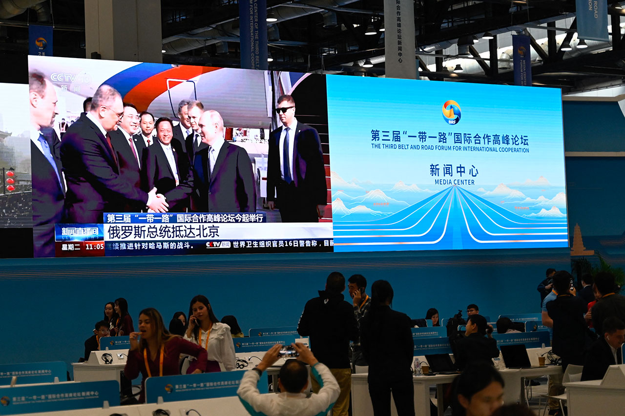 2023年10月17日，在"一带一路"国际合作高峰论坛媒体中心的屏幕上显示俄罗斯总统普京抵达北京的新闻报道。（法新社）