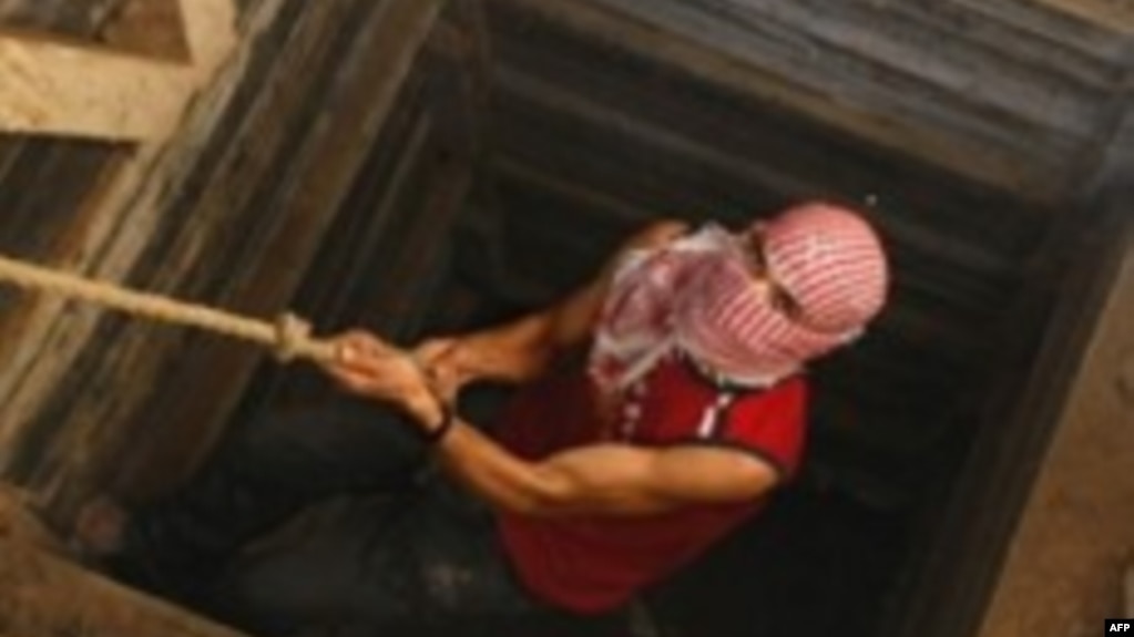 資料照片：一名巴勒斯坦人爬出連接加沙與埃及的隧道（2009年12月10日）（法新社）