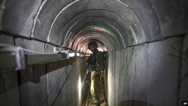 在以色列和加沙边境，一名以色列士兵带领记者参观一条据称是哈马斯武装人员用于潜入以色列境内的隧道。（2014年7月25日）