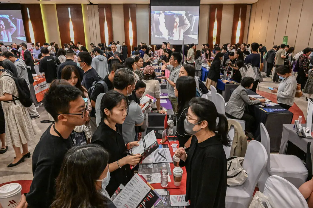 北京的招生会上，美国大学宣传摊位前徘徊的中国学生。中国赴美留学生人数近年来有所下降。