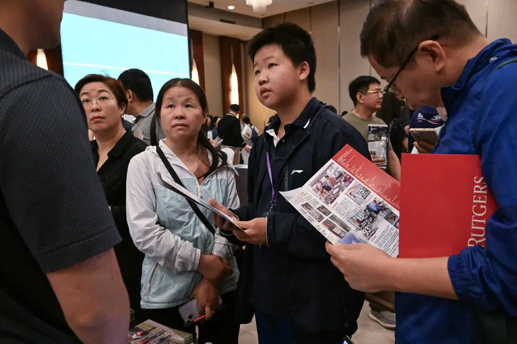 在北京今年9月的美国大学招生会上，在罗格斯大学展位前了解情况的中国学生。
