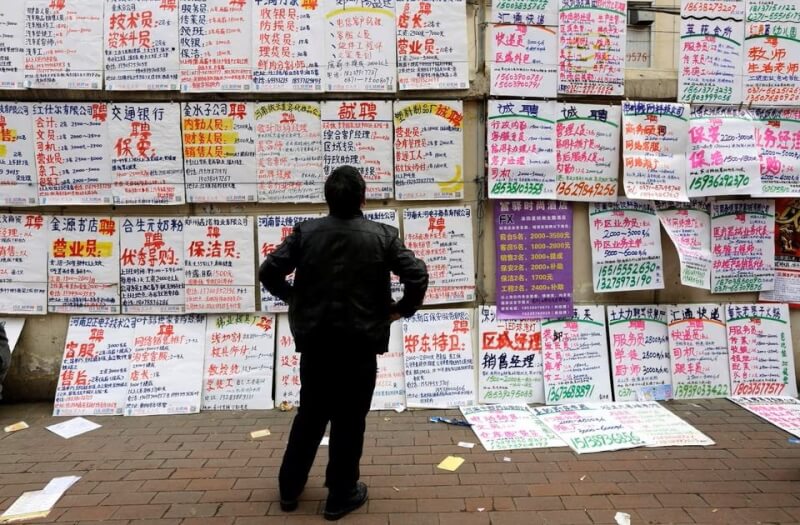 图为中国河南一名男子在浏览就业讯息。（路透社）