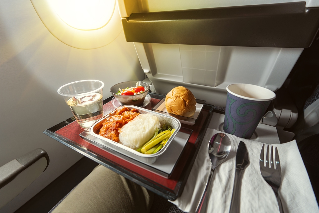 不少旅客搭乘飛機時,習慣將食物直接放在座椅後方的小桌板上。(示意圖:shutterstock/達志)