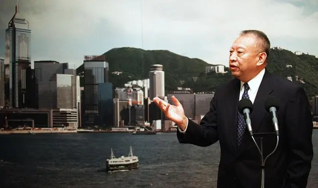背靠香港海景,董建华对着麦克风讲话