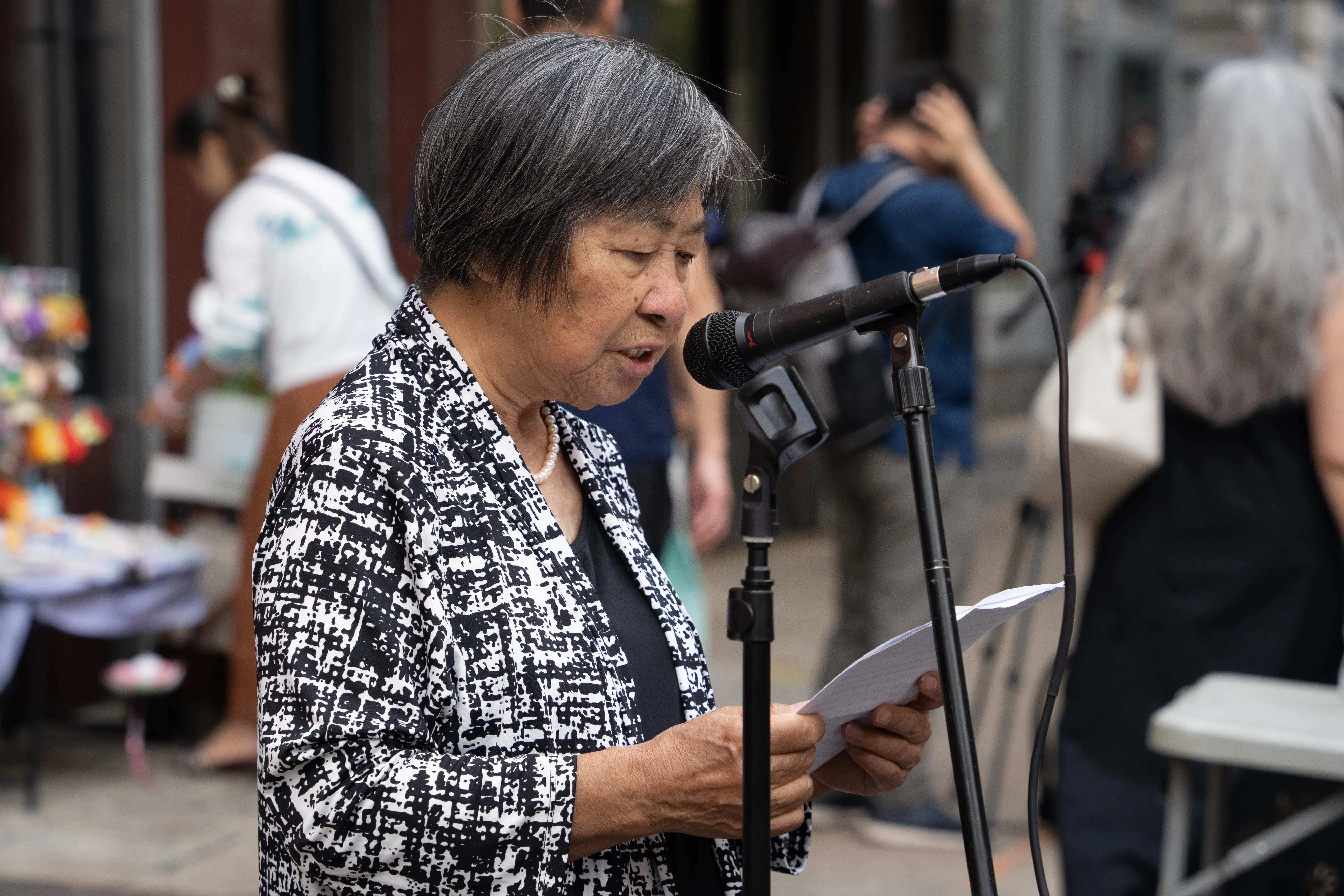 2026年9月19日，三退义工童女士在费城唐人街庆祝4.66亿华人“三退”集会上发言。（李臻婷／大纪元）